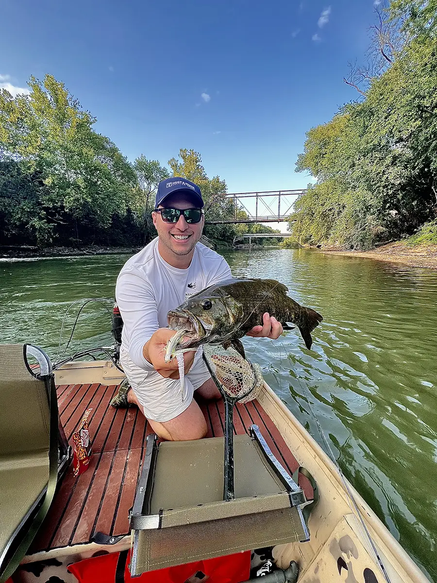 Brad Fitzgerald holding fish on river