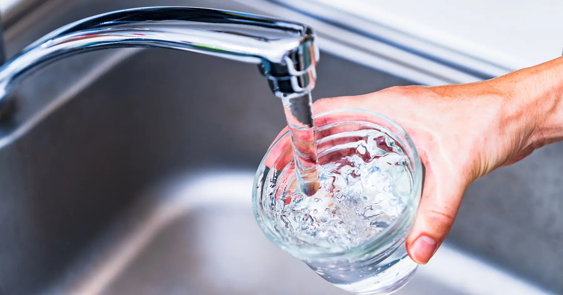 filling glass of water in sink