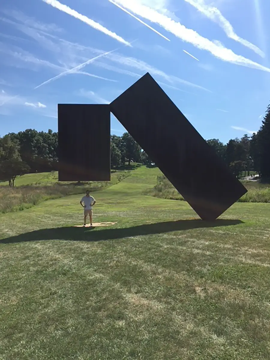 John standing with sculptor in park