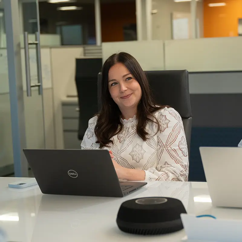 woman smiling in meeting with laptop